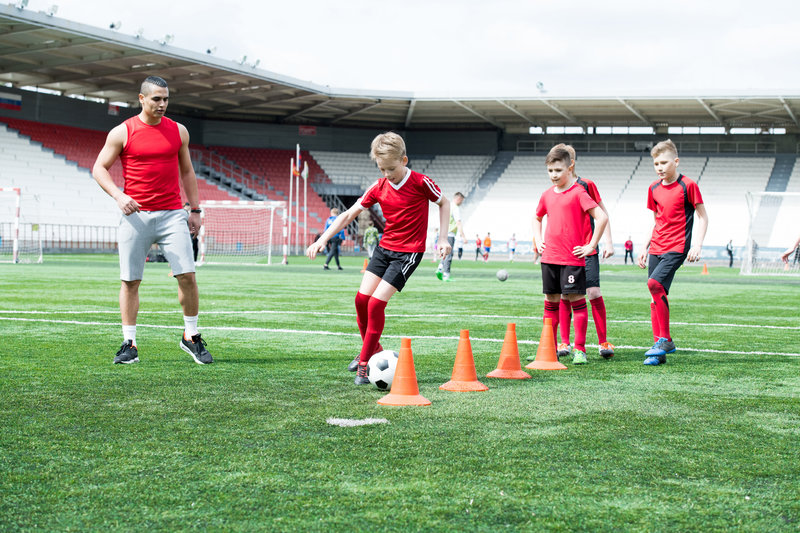 Young footballers training inside a stadium